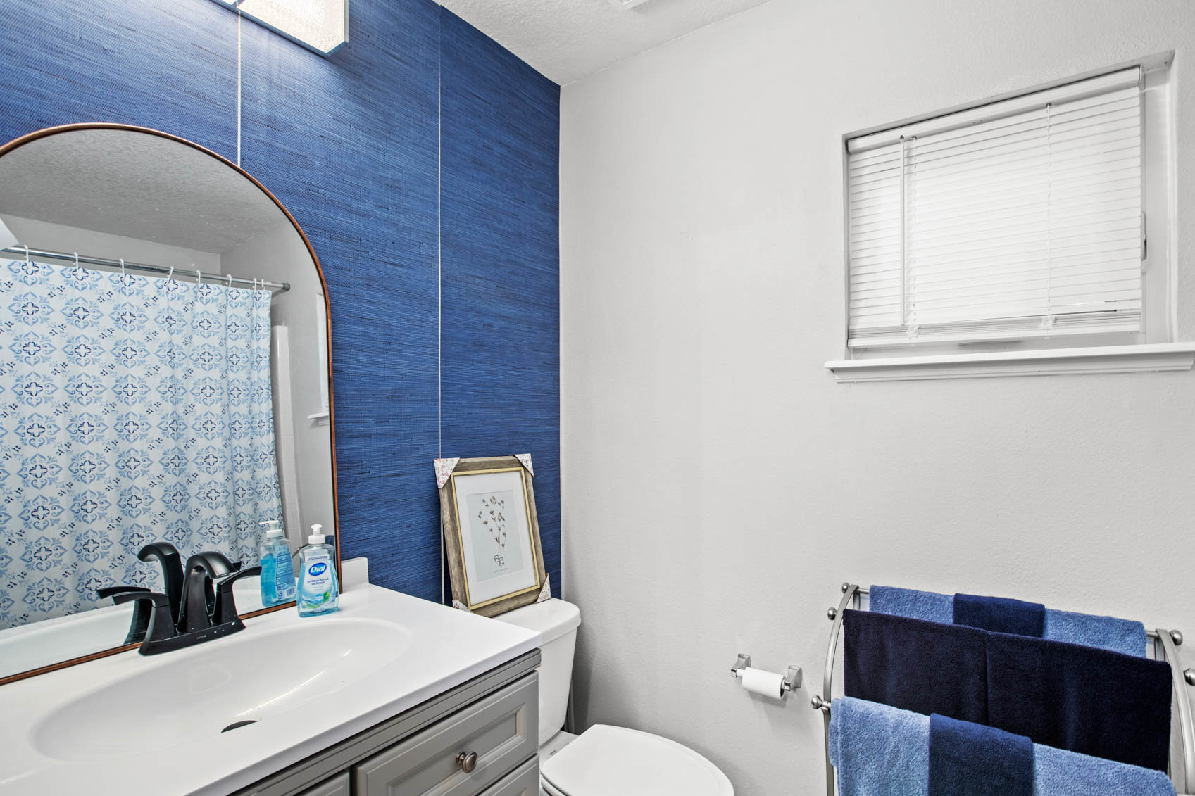 bathroom with blue wall and curved vanity